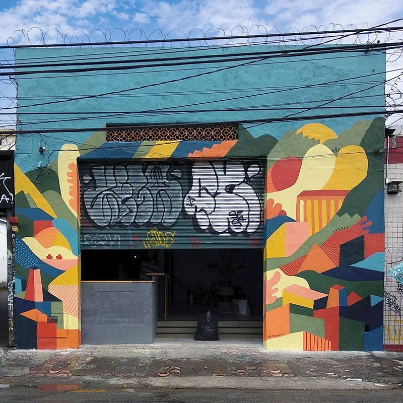 Fachada do bar Sabático com um mural pintado com formas orgânicas e coloridas.